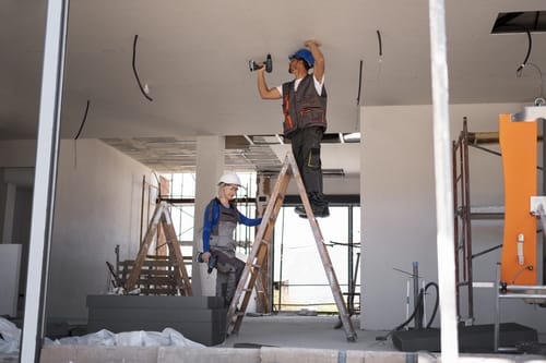 03a1da30-7b48-47aa-81d5-b0565924331e.full-shot-man-woman-standing-ladder